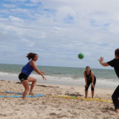 Four people playing handball on the beach