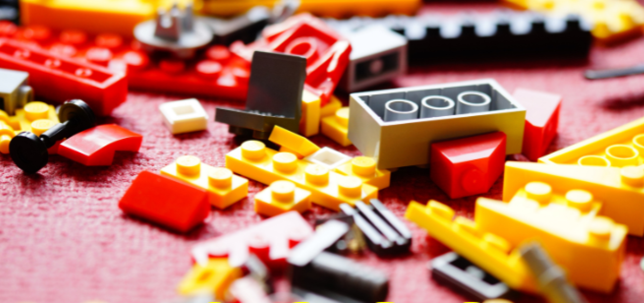 Assorted Lego pieces scattered on a red mat.