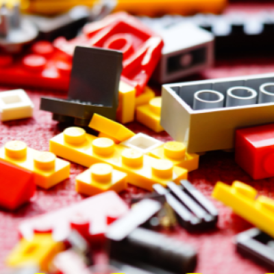 Assorted Lego pieces scattered on a red mat.