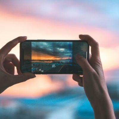 image of someone holding their phone up to capture the sunset