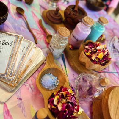 Table showing cards, nature materials and small glass bottles with coloured sand and glitter