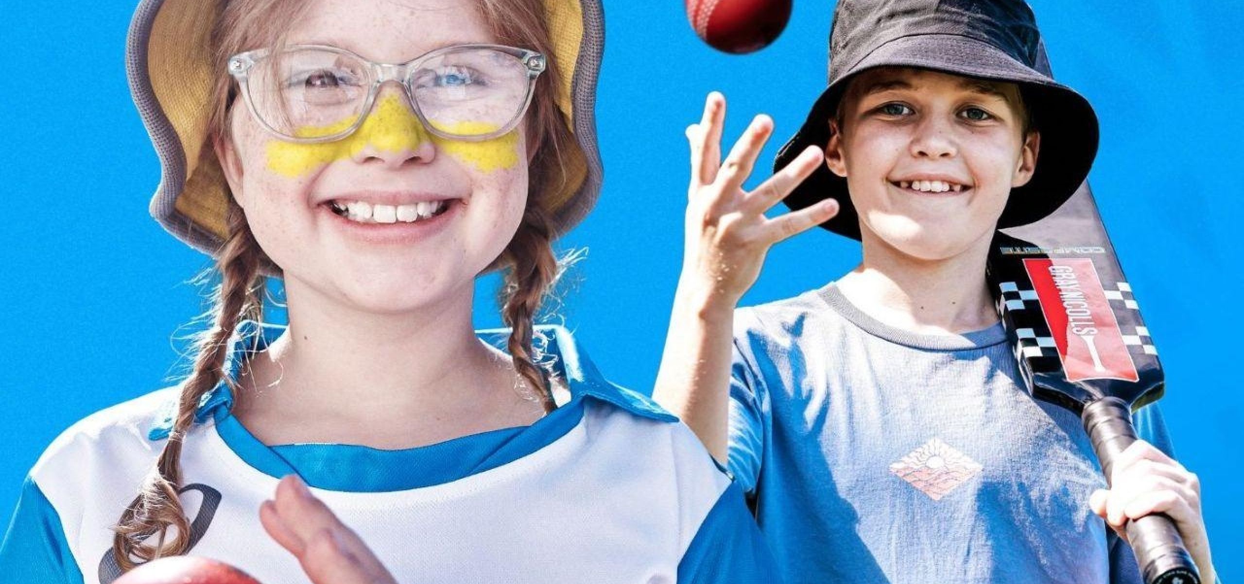 Two children holding cricket balls
