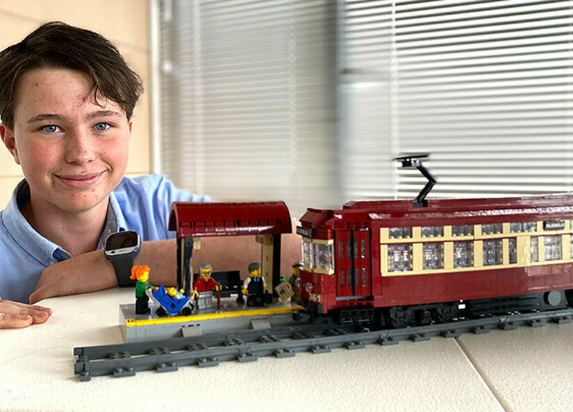 Person with LEGO model of an old tram