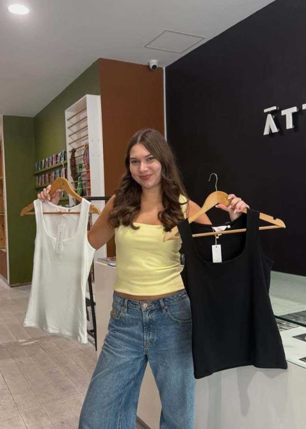 Shop assistant holding up garments