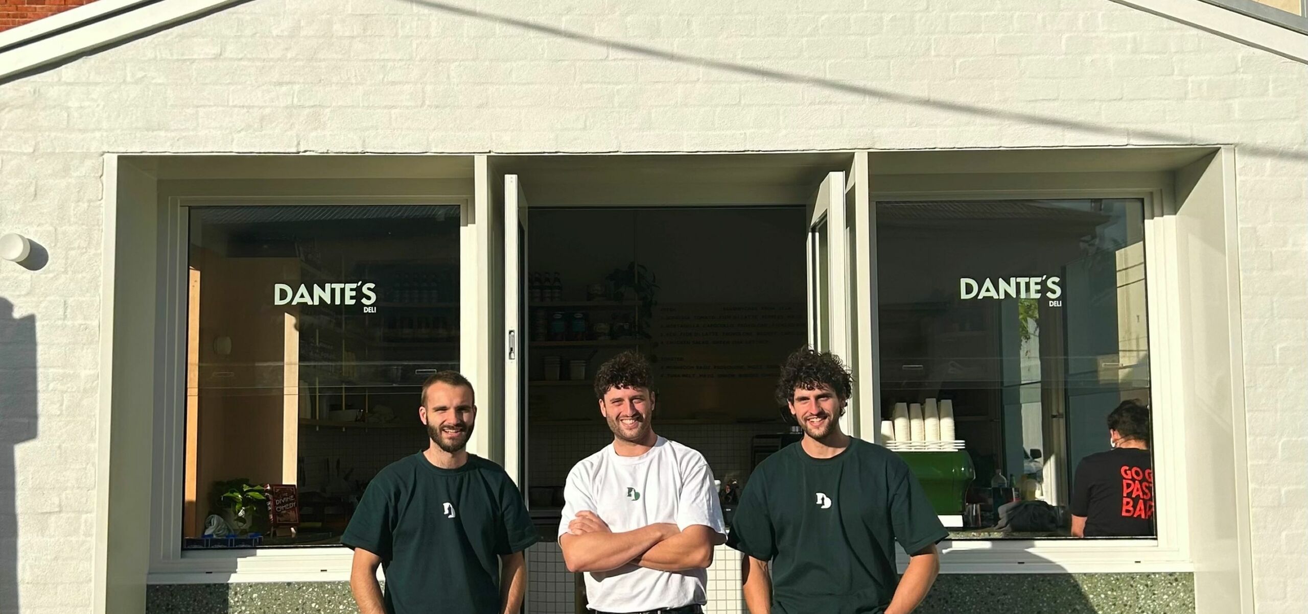 Three people standing in front of a white building