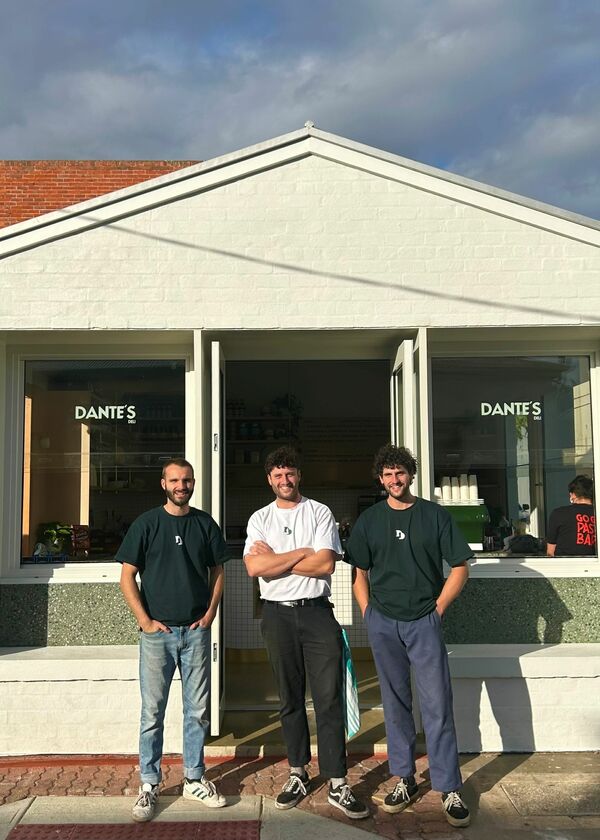 Three people standing in front of a white building