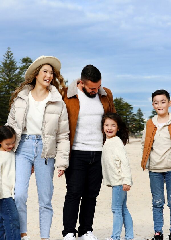 Family with two adults and three children standing on the Glenelg beach