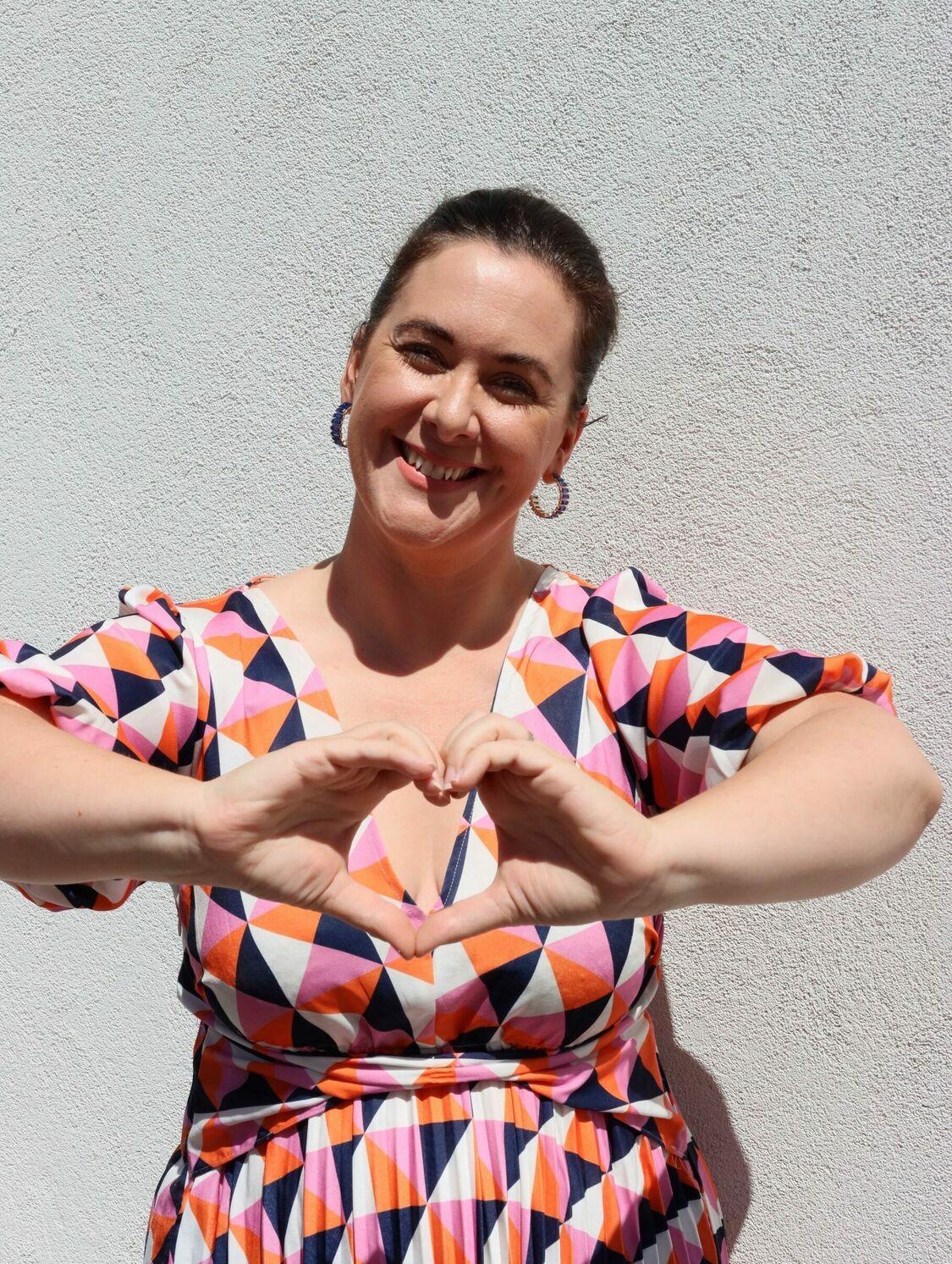 Jacqui from Healthful Wellness Hub making a heart shape with her hands.