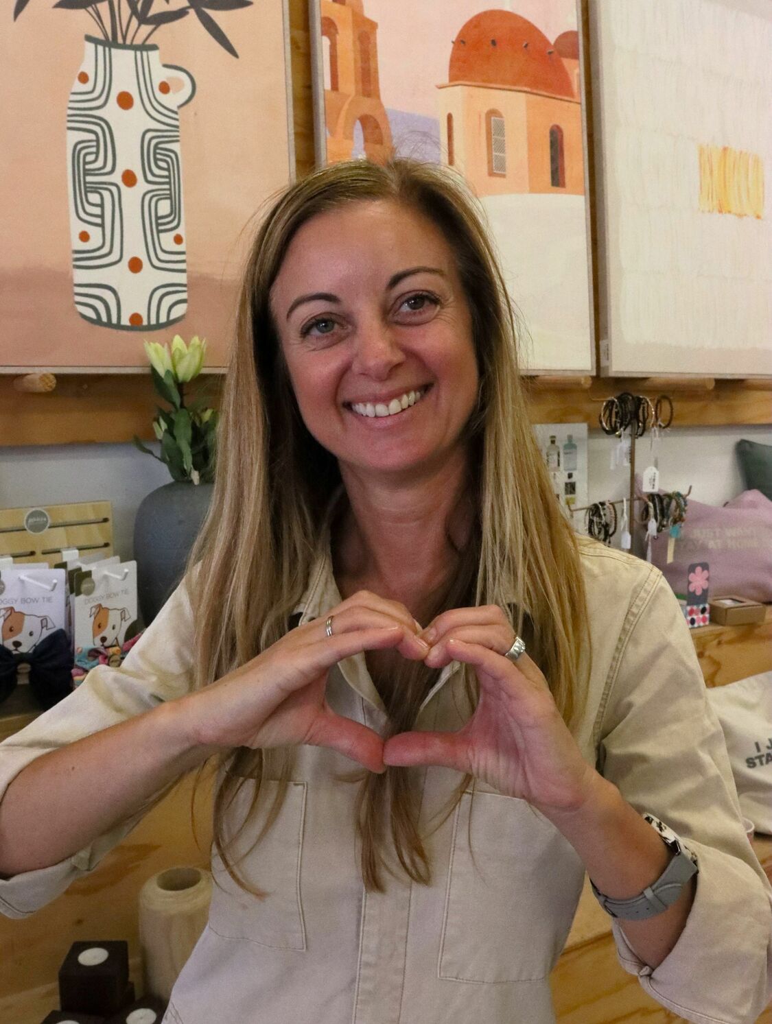 Gilia from Attitudes Boutique making a heart shape with her hands.