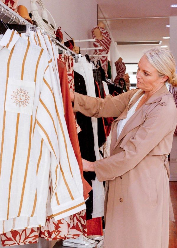 lady looking through rack of clothes