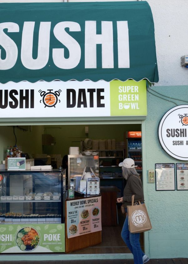 Person walking past sushi shop