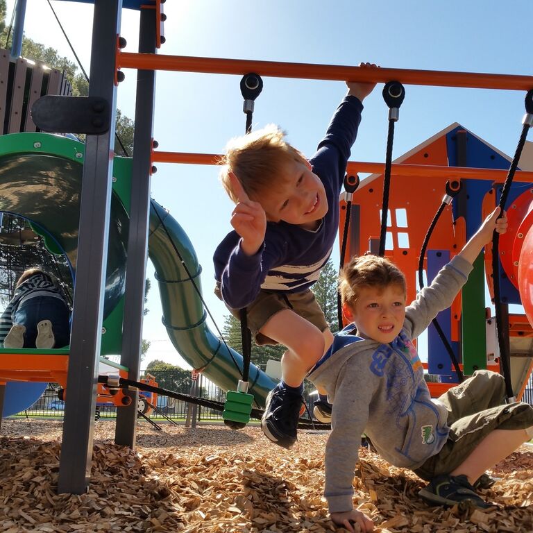 two children playing on playground equipment