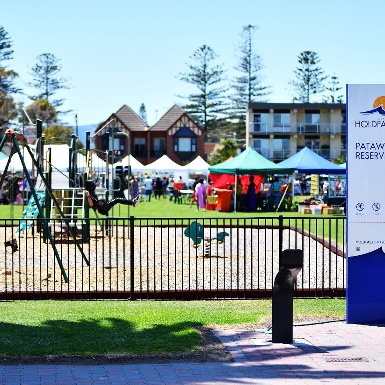 fenced playground with sign that reads: City of Holdfast Bay Patawilya Reserve